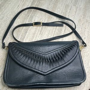 VTG black leather crossbody bag with intricate leather details on flap.
